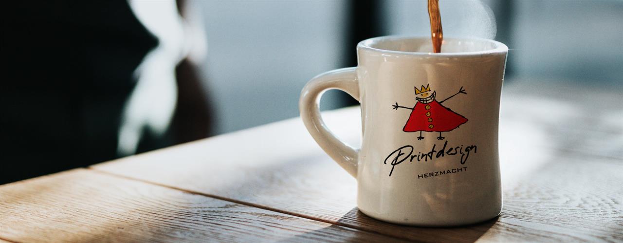 Darstellung von Printdesign durch den aufgedrucken HERZMACHT König auf einem Kaffeebecher | HERZMACHT marketing